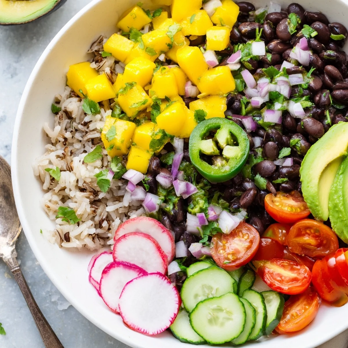 Zesty lime and fresh vegetables enhance delicious Mango Salsa Black Bean Bowls served warm.