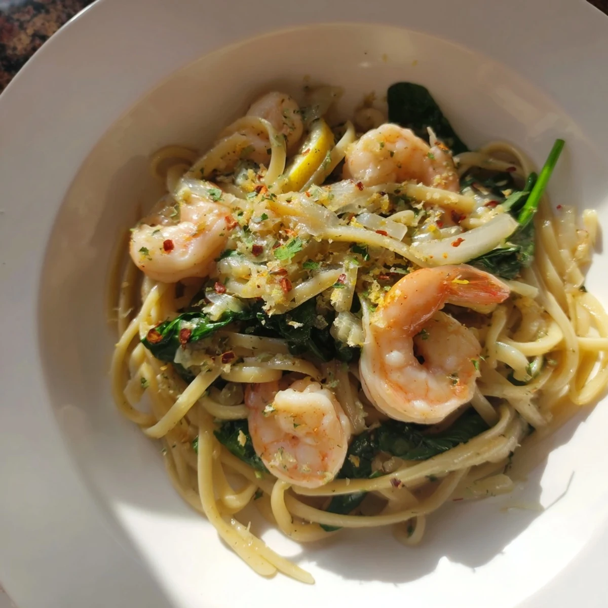 Tender shrimp spinach herb pasta tossed in garlic white wine sauce, garnished with Parmesan.