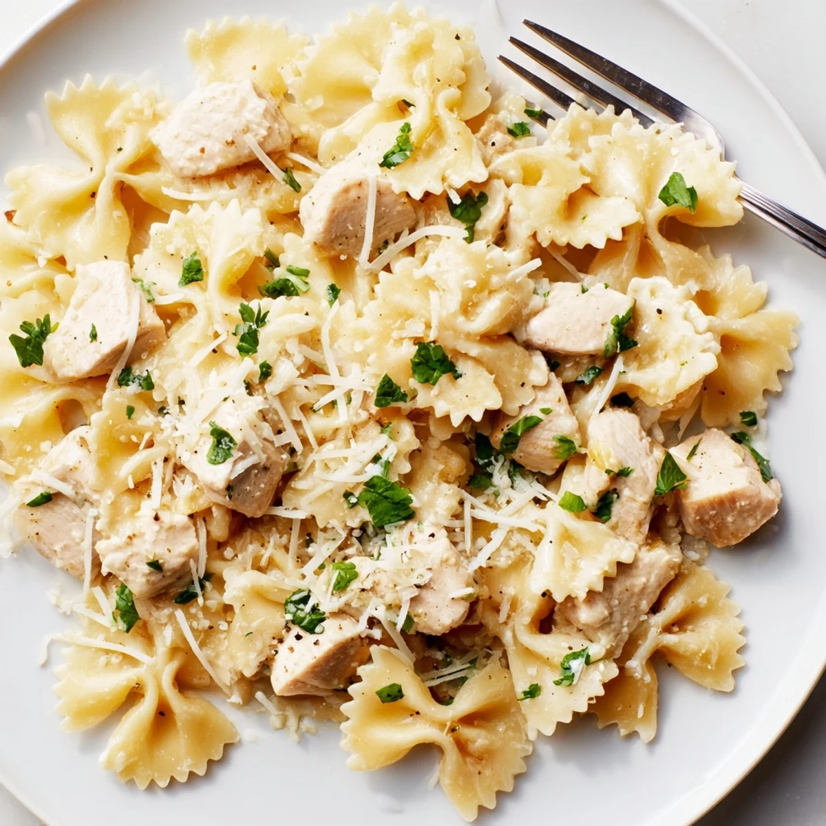 Tender Mozzarella Garlic Butter Chicken Bowties served with fresh parsley and grated cheese.  