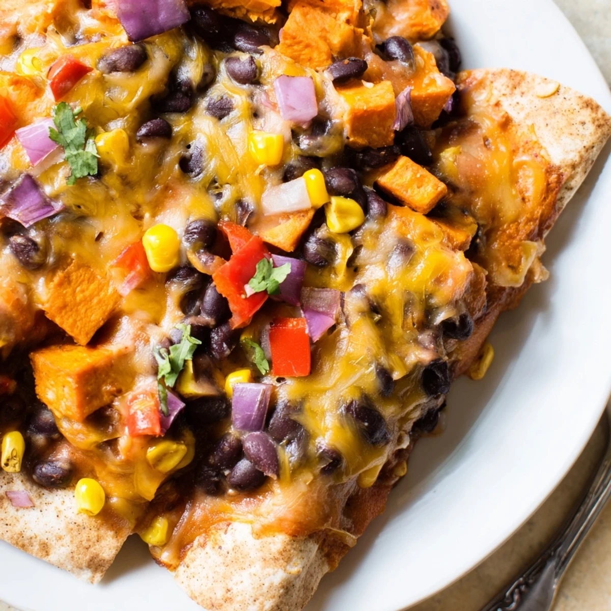 Aromatic Spicy Black Bean & Sweet Potato Enchiladas topped with melted cheese and fresh cilantro.  