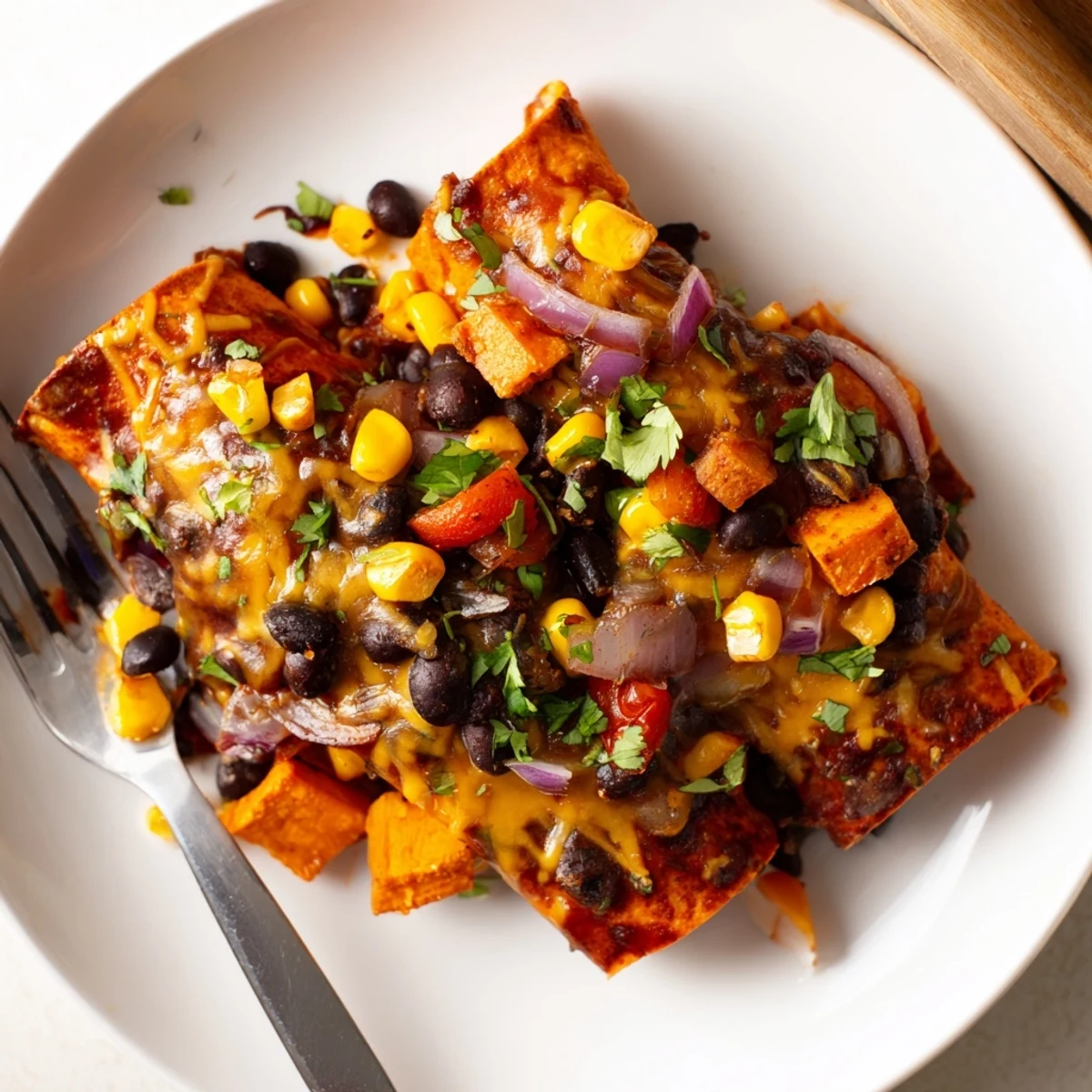 Deliciously baked Spicy Black Bean & Sweet Potato Enchiladas drizzled with rich enchilada sauce.