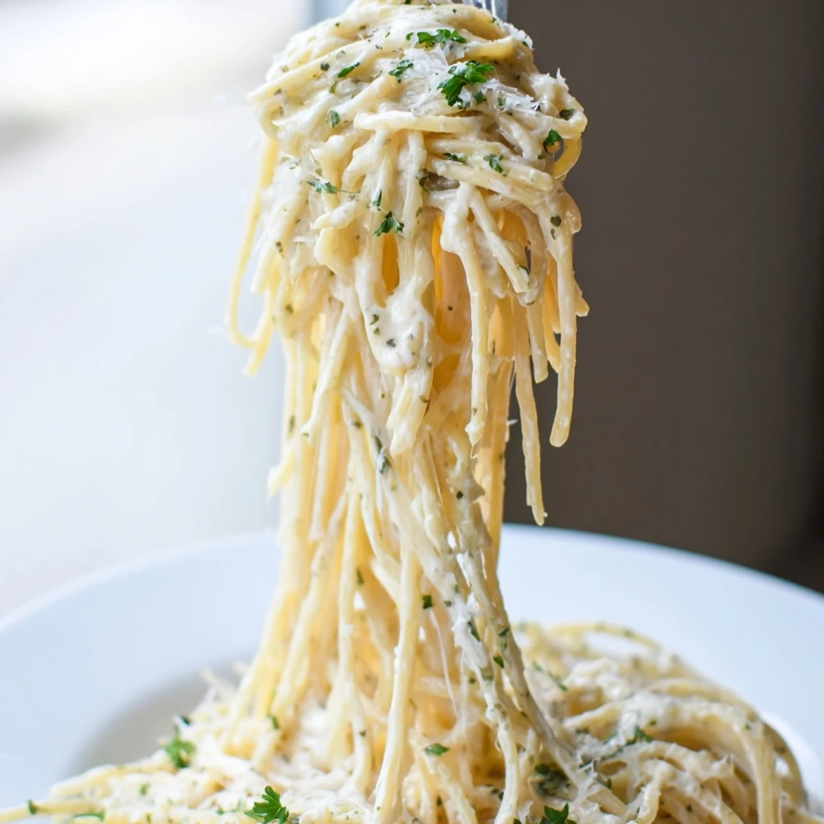 Close-up of golden, melted cheese coating spaghetti; a delightful creamy three-cheese spaghetti dish.