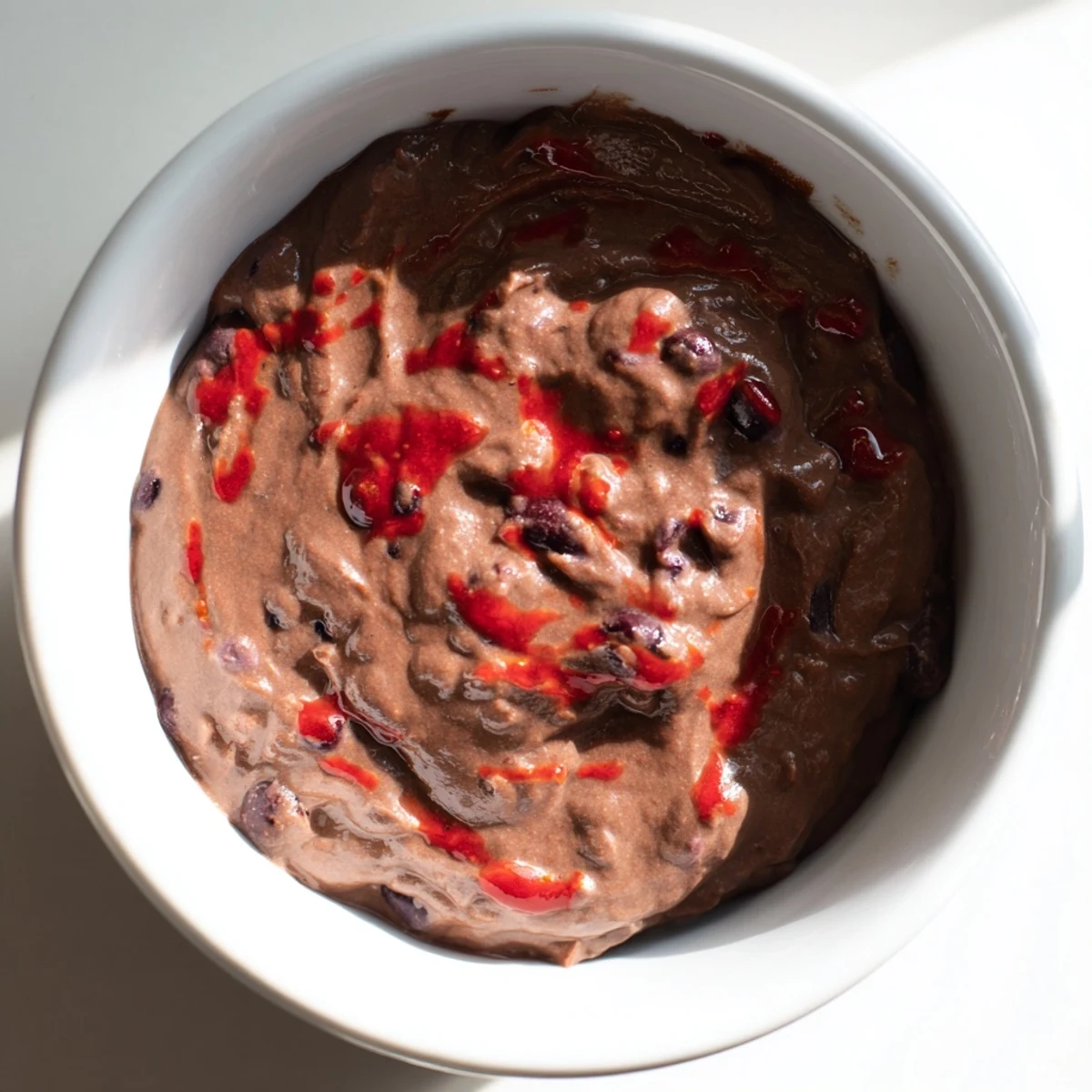 Creamy, spicy black bean dip served in a bowl, perfect with colorful tortilla chips.