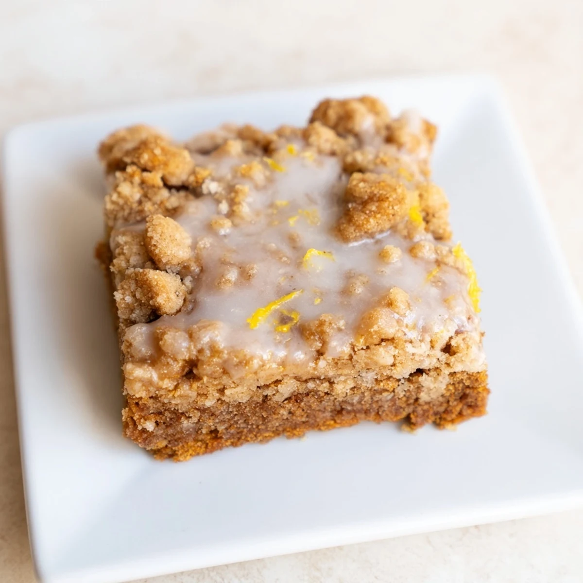Freshly baked Lemon-Glazed Gingerbread Crumble Bars, a festive treat with warm gingerbread aromas.