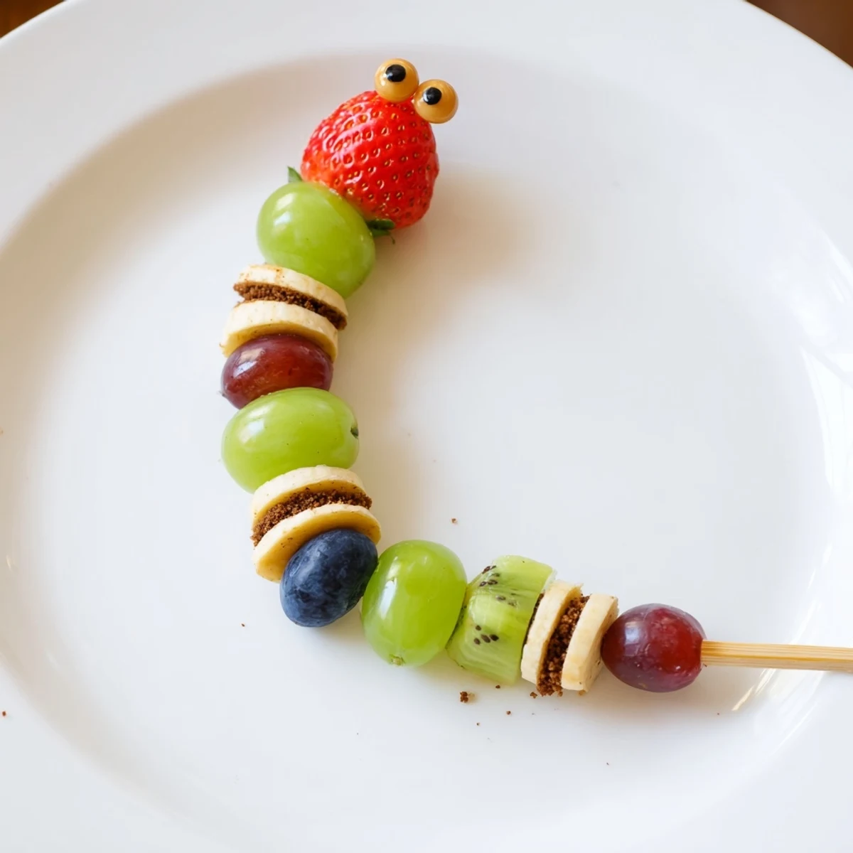 Close-up of playful Caterpillar Fruit Skewer design with juicy grapes and berries ready to enjoy.
