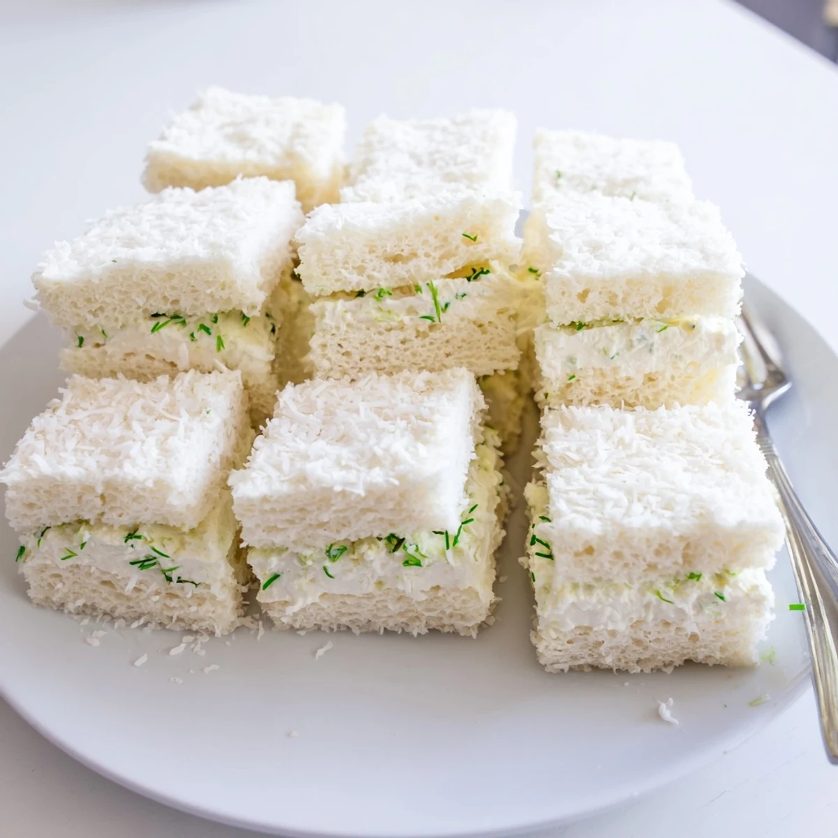 Creamy filling bursting from these Snowball Tea Sandwich Bites, perfectly coated in sweet coconut flakes.