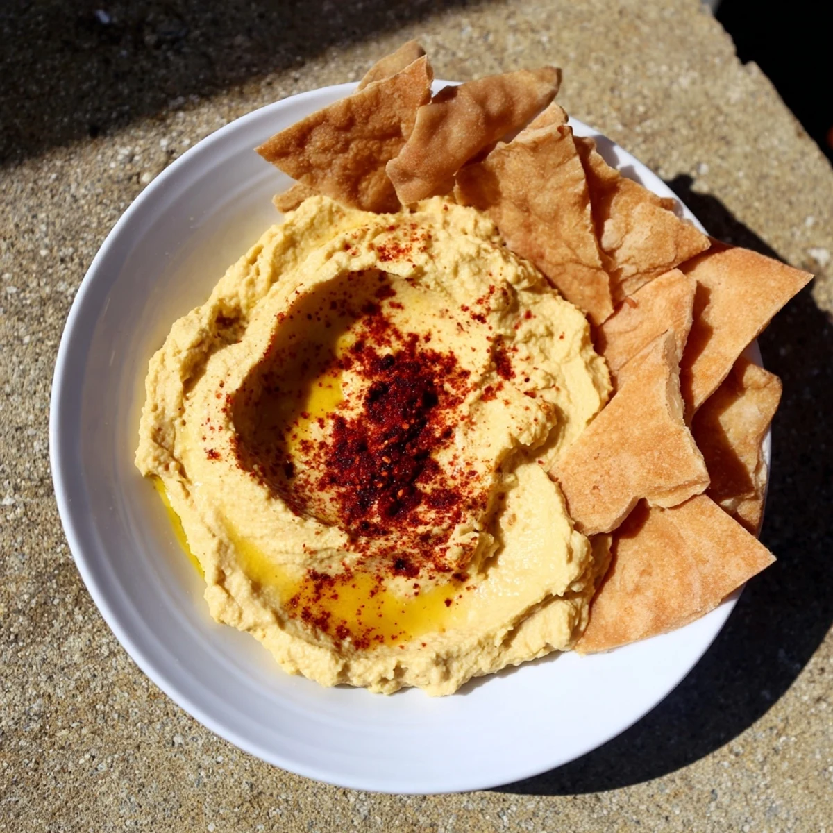Vibrant photo depicts The Sahara Dune appetizer; perfect serving of creamy hummus and crispy, spiced pita chips.