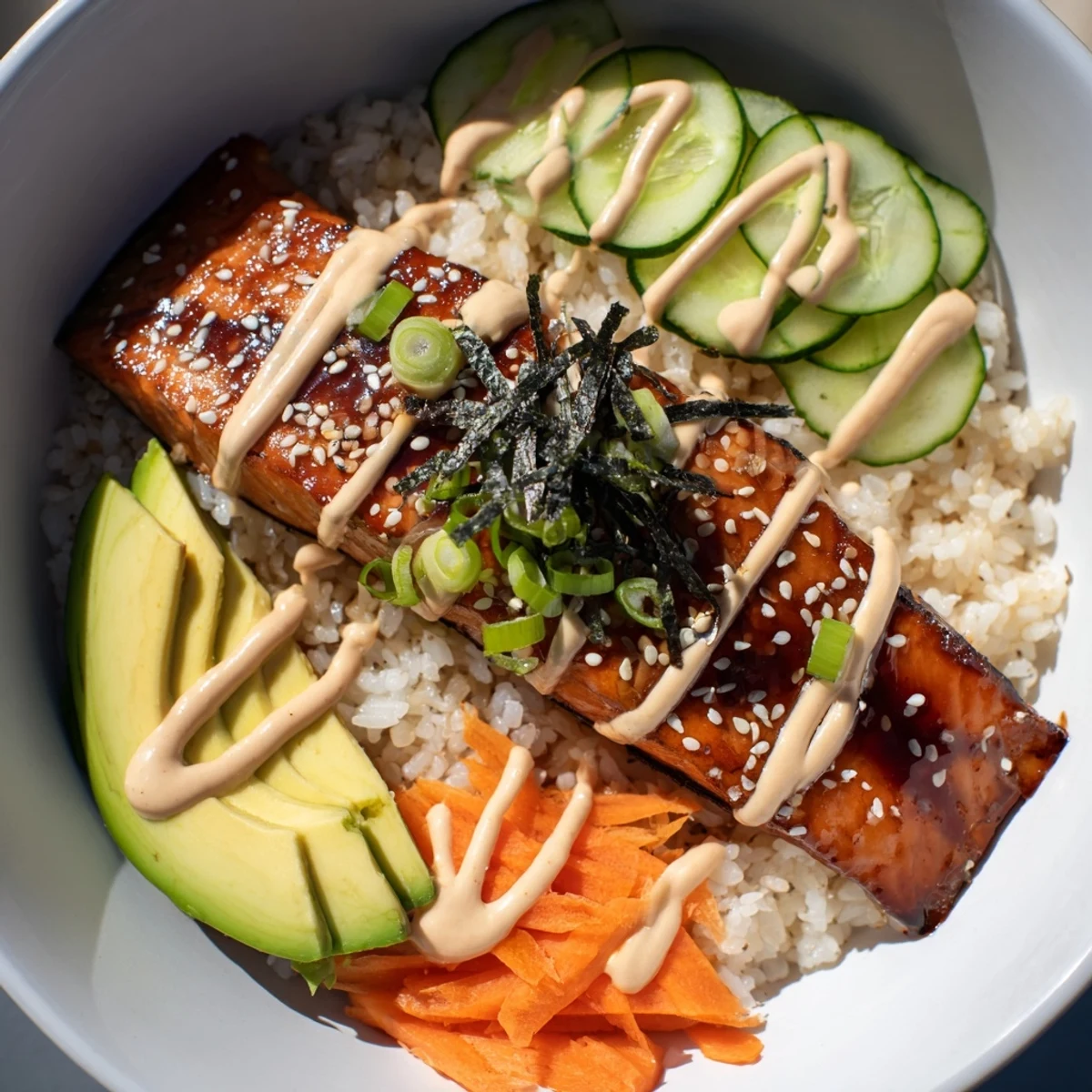 A beautiful, plated teriyaki salmon rice bowl with glistening salmon, vegetables, and creamy sriracha mayo.