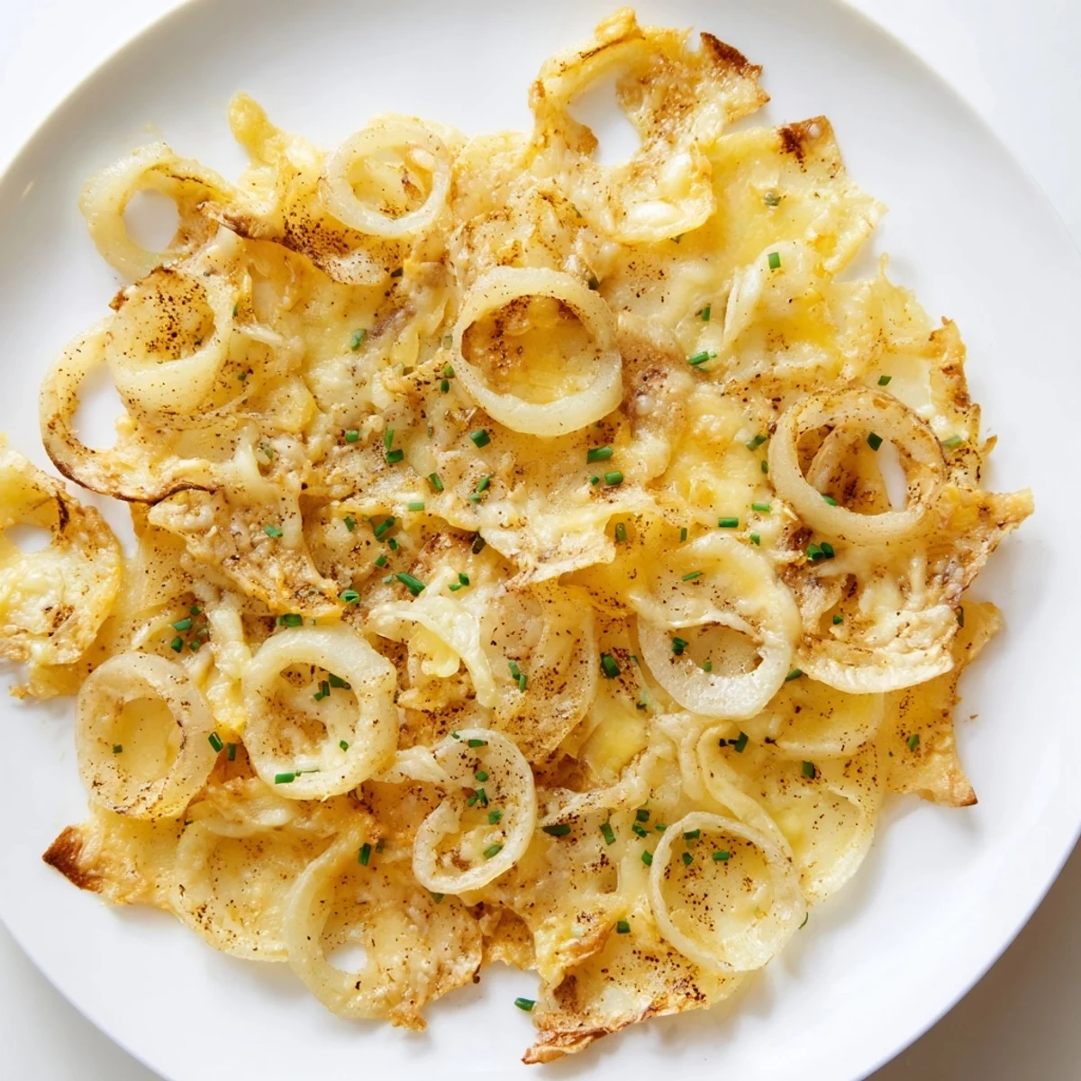 Melted cheese hugging tender, browned onions: delicious image of fresh-made crispy onion cheese chips.