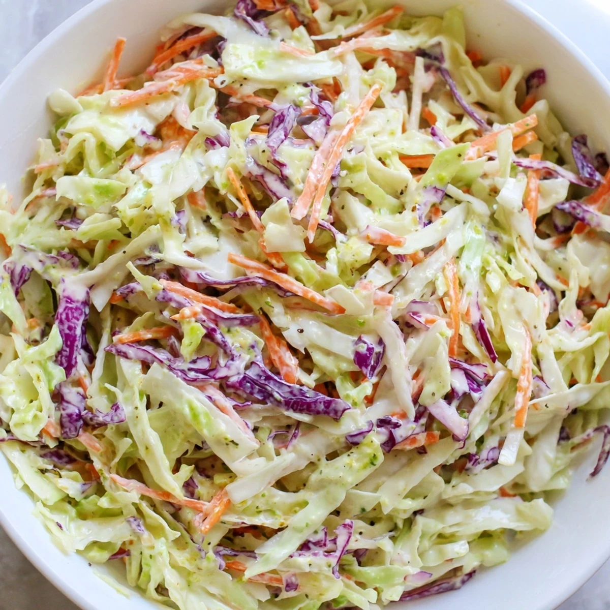 Vibrant green and red cabbage with carrots in a creamy dressing, perfect for a Coleslaw With Creamy Dressing side dish.