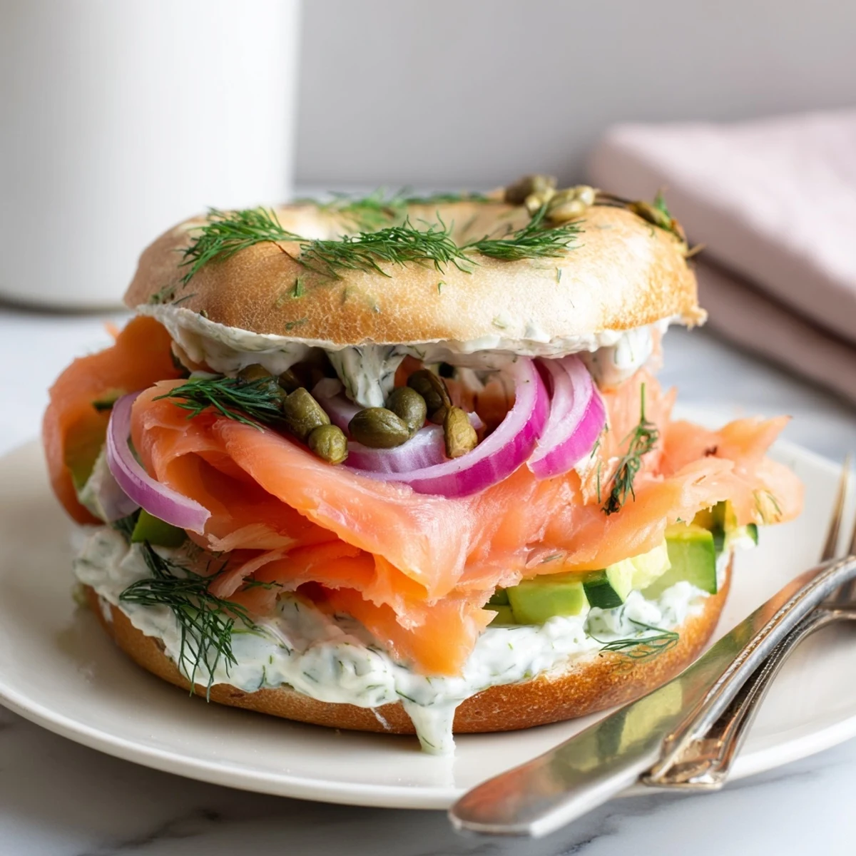 Silky smoked salmon & dill bagel sandwiches topped with fresh cucumber and red onion.  