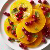 Brightly colored orange slices and cranberries, ready to be tossed in a simple honey lime dressing