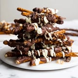Sweet white chocolate drizzles highlight the decadent, homemade Chocolate Covered Pretzel Stick Stacks, ready to eat!