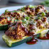 Crisp zucchini halves stuffed with shredded BBQ chicken and cheese, baked to a golden finish.