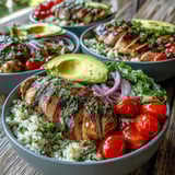 Juicy grilled chicken slices marinated in cilantro lime sit atop fluffy cauliflower rice in this Low-Cal Cilantro Lime Chicken and Cauliflower Rice Bowl.