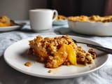 A white plate with a slice of peach pie on it.