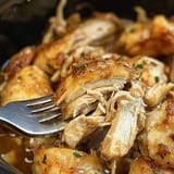 A fork is stuck in a bowl of chicken.