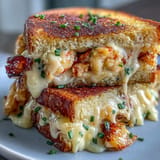 Decadent Lobster Grilled Cheese sandwich, pan-fried to perfection with buttery crust.