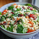 Tender orzo pasta in a warm Greek Style Orzo Salad, ready to serve.