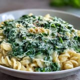Velvety creamy spinach pasta, ready to serve with fresh Parmesan garnish.