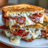 Mouthwatering Pepperoni Pizza Grilled Cheese with crispy sourdough, bubbling cheese, and dipping sauce.
