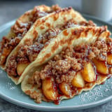 Fluffy peach cobbler pancake tacos overflowing with warm cinnamon fruit.