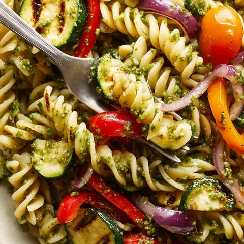 A bowl of pasta salad with grilled zucchini and pesto vinaigrette.