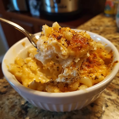 A white bowl filled with macaroni and cheese.