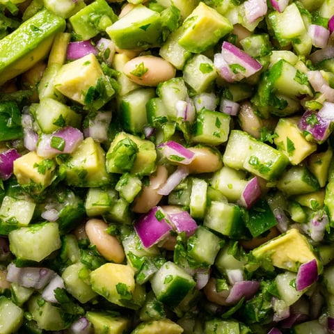 A cucumber and avocado salad with a bean dip.