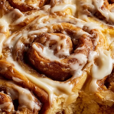 A close up of a cinnamon roll cake with icing.