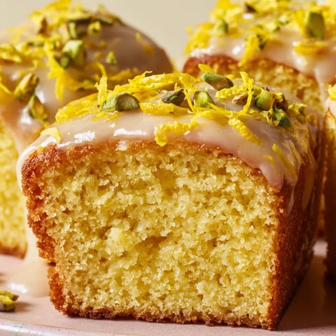 A slice of butter-yellow pistachio citrus sheet-cake bars.