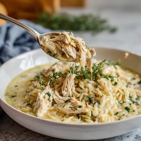 A bowl of creamy lemon herb chicken orzo.