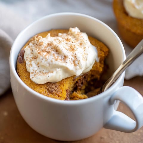 A warm and comforting Creamy Pumpkin Muffin Mug Cake, fresh from the microwave.