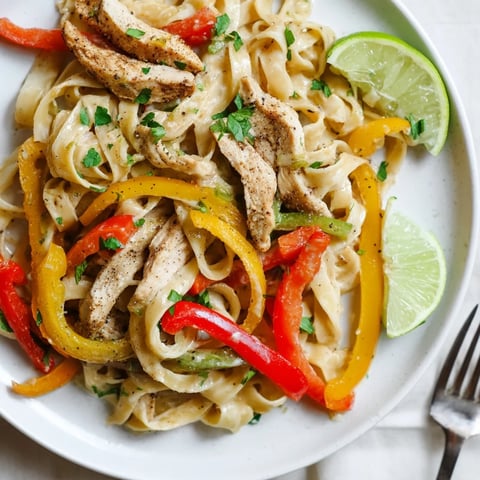 Creamy Alfredo Chicken Fajita Pasta served with colorful sautéed peppers and fresh parsley.  
