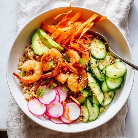 Succulent shrimp and avocado sushi bowls topped with vibrant, fresh vegetables.