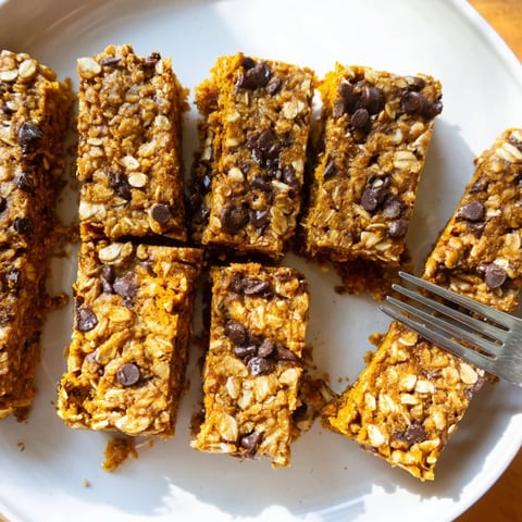 Moist pumpkin muffin protein bars topped with chocolate chips, perfect for breakfast.