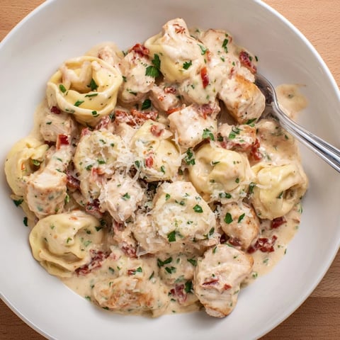 Tender Zesty Cajun Garlic Parmesan Chicken Tortellini in creamy sauce with fresh parsley.