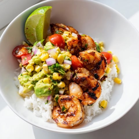 Juicy grilled shrimp bowl topped with vibrant avocado corn salsa and lime.  