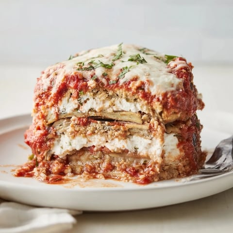 Layers of Eggplant Parmesan Lasagna, with bubbling mozzarella and rich marinara sauce.  