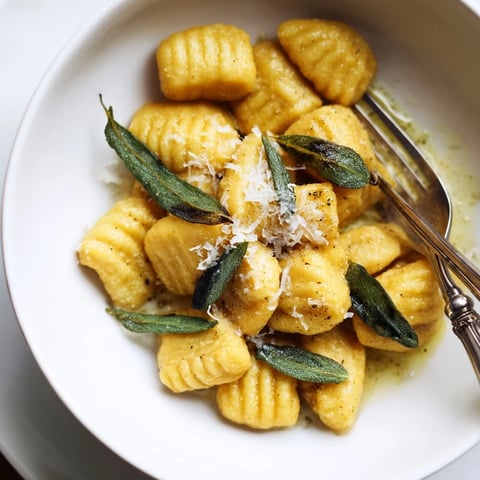 Homemade sweet potato gnocchi drizzled with rich sage butter, a cozy Italian delight.  