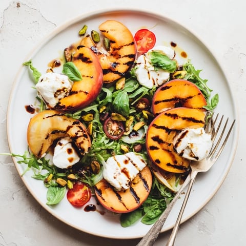 Grilled Peach & Burrata Salad with vibrant colors, drizzled with balsamic glaze and fresh basil.  