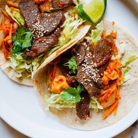 Tender Korean BBQ Beef Tacos with Kimchi, topped with fresh cilantro and sesame.  