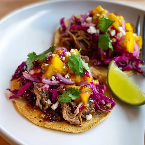Tender duck confit tacos topped with zesty mango chutney for a flavorful bite.  