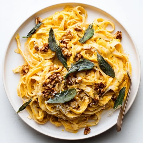 Creamy pumpkin pasta with sage and walnuts, perfect for cozy autumn dinners.  