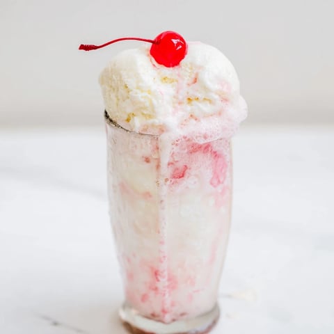 Vanilla ice cream melting into fizzy homemade cream soda, the perfect refreshing float.