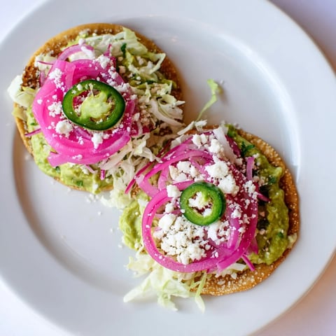 Tangy 5-Minute Pickled Red Onions layered on tacos, complete with crispy avocado crema and fresh cilantro.