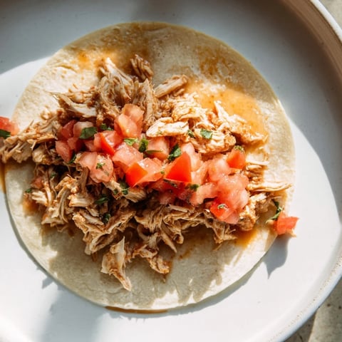 Juicy Crock-Pot Shredded Chicken Tacos spilling out of soft tortillas, ready to customize with toppings.