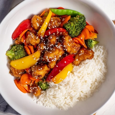 Steaming Chicken Stir-Fry with Vegetables and Rice, a colorful and savory Asian-inspired main dish.