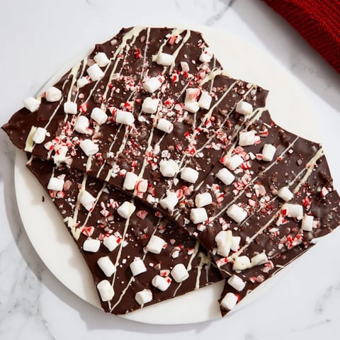 Rich, dark Hot Chocolate Bomb Bark with white chocolate drizzle and colorful sprinkles, ready to break.