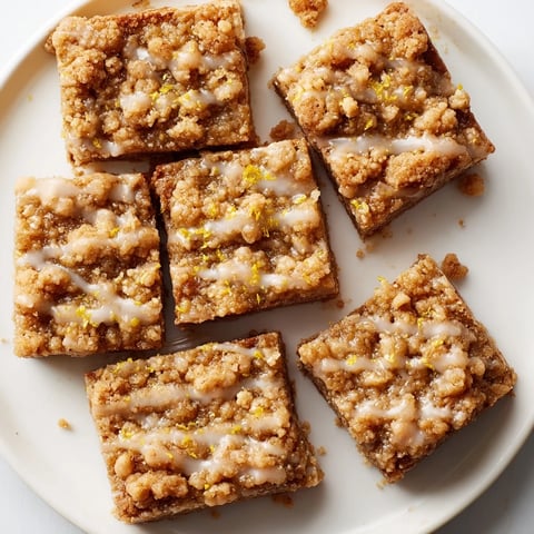 Warm Lemon-Glazed Gingerbread Crumble Bars, aromatic with spices and topped with tangy lemon glaze.
